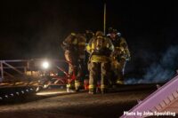 Firefighters on the roof of a building with aerial ladder