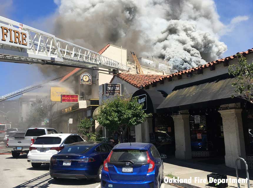 Aerial at a structure fire in Oakland with smoke billowing