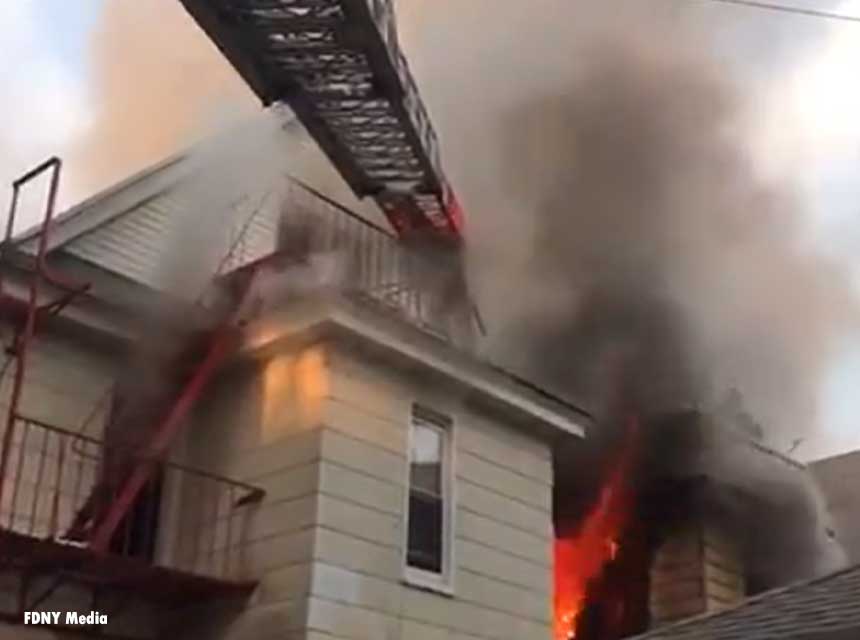 Flames shoot from the roof of a home in Queens