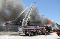 Aerial device with elevated master stream operating as smoke billows from a building