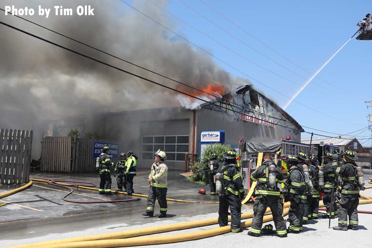 Fire vents from the roof of a building in South Holland as firefighters work