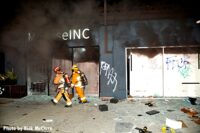 LAFD members walk past graffiti-covered buildings