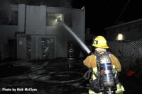 Firefighter puts a hosestream through a window