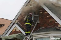 Chicago firefighter on a ladder at the window with smoke condition