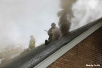 Chicago firefighter on the roof of a burning home with smoke