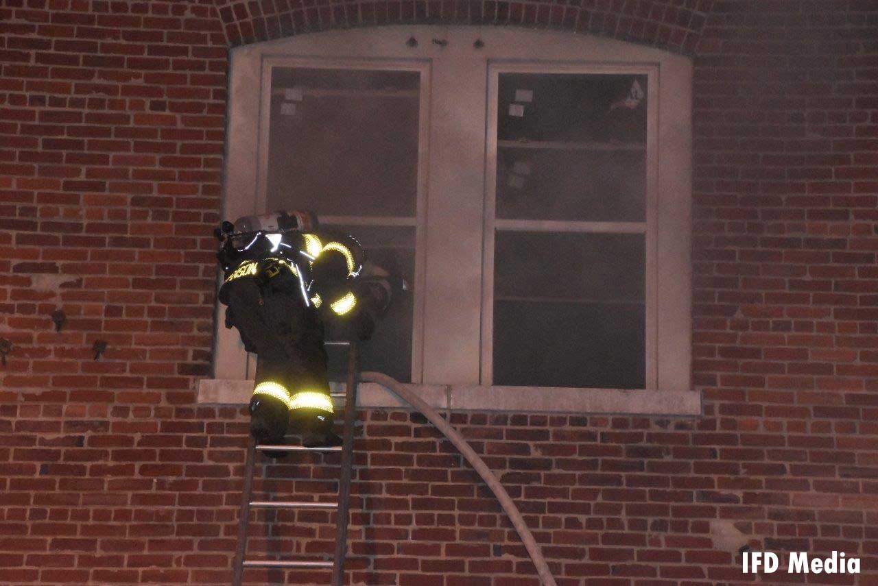 Firefighter on a ladder with a hoseline