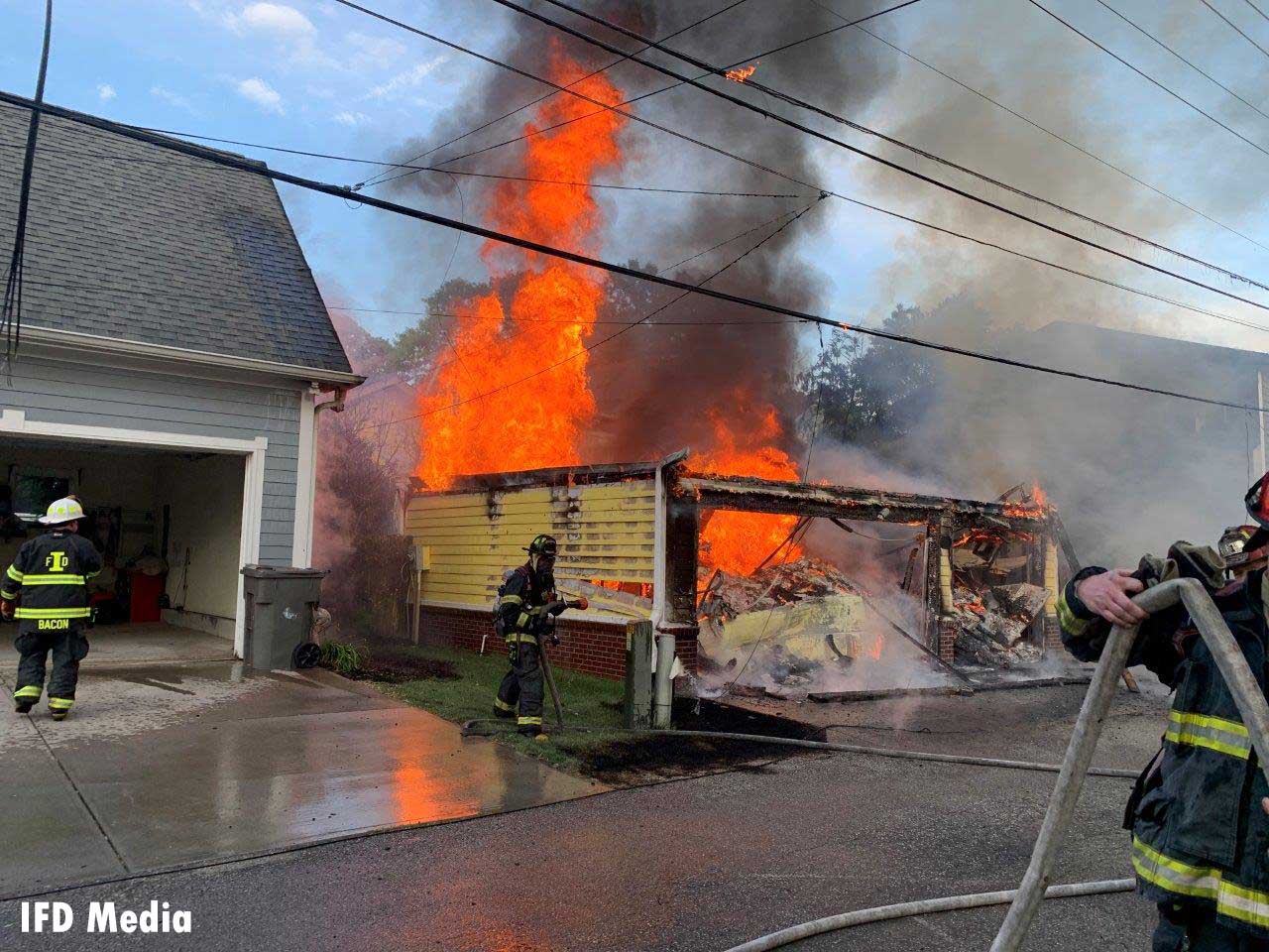 Flames shoot from a structure in Indianapolis as firefighters work