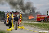 Rubbish fire burning with fire apparatus and firefighters