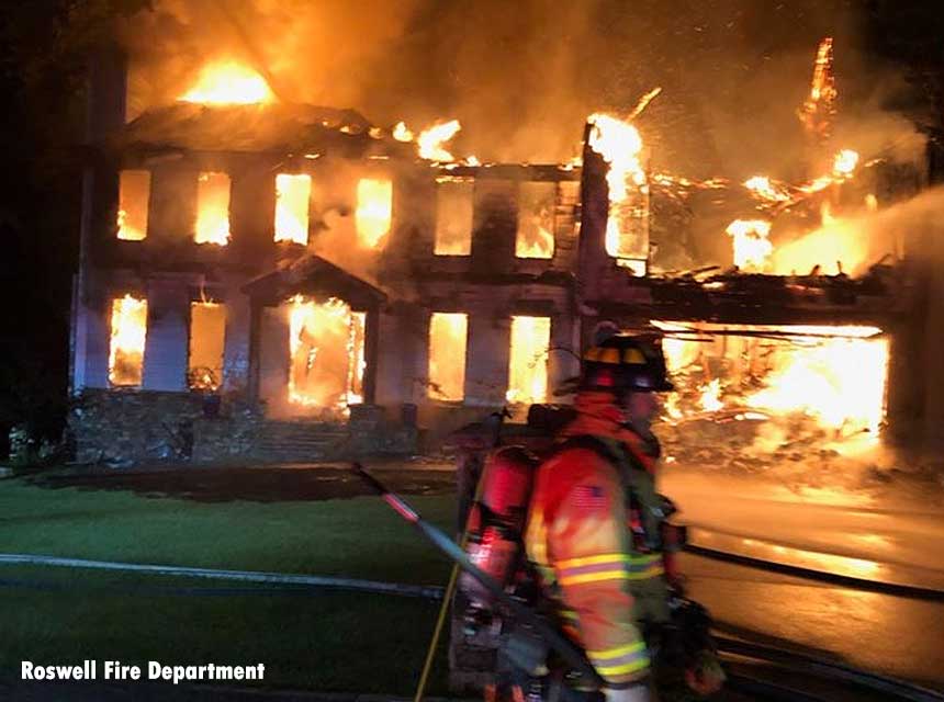 Firefighter in front of a burning home