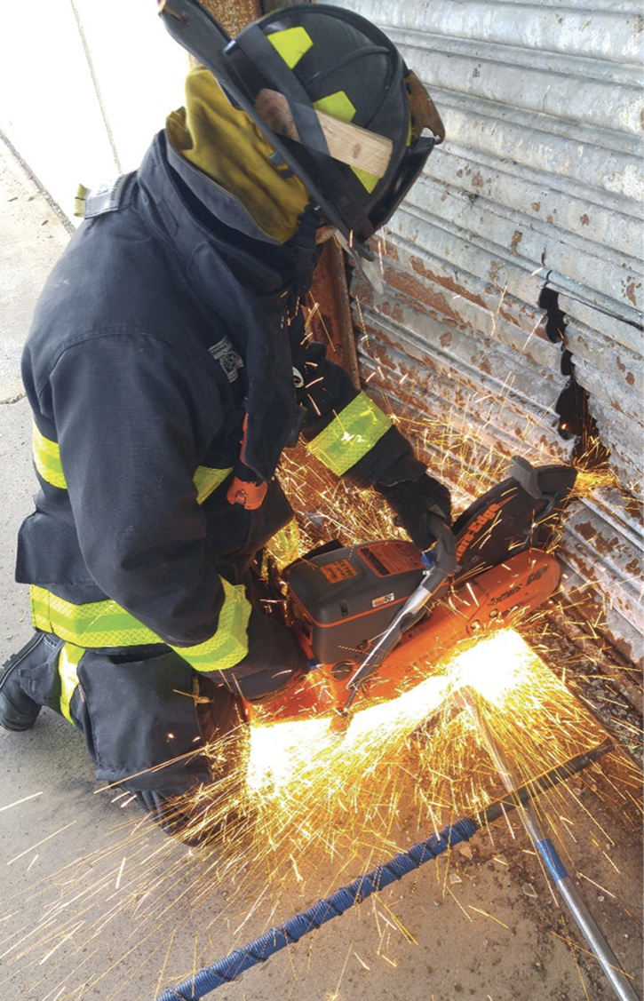 Truck company members drill on rotary saw operations on a commercial building.