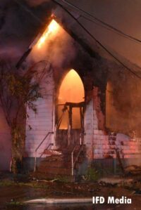 Flames cast an eerie light through the front of the church