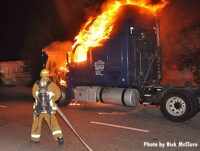 A Los Angeles firefighter with a hoseline at a burning big rig