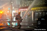 A firefighter with a hoseline puts water on the fire