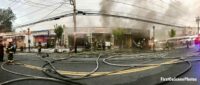 Panorama view of hoselines and multiple businesses burned in fire