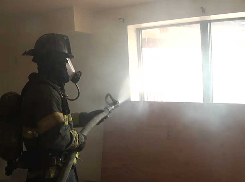 Firefighter with smooth bore nozzle performing hydraulic ventilation