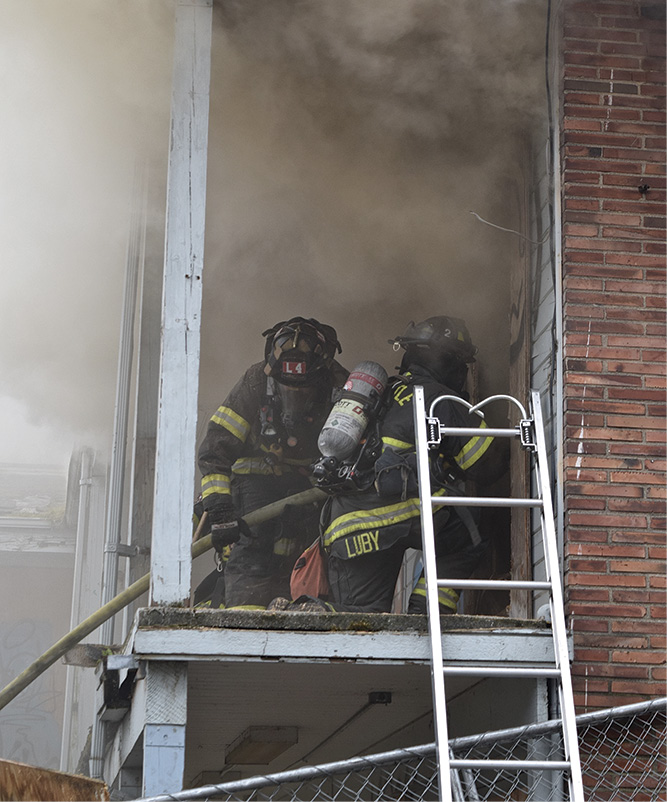 Crews create an entry point and are met with smoke under light/moderate pressure at the top of the door.