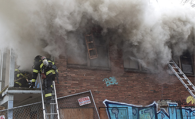 Crews create an entry point and are met with smoke under light/moderate pressure at the top of the door.