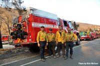 Firefighters near apparatus during wildfire fight