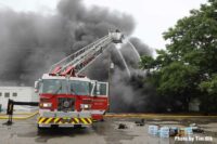 Elevated master stream use as smoke rises from structure