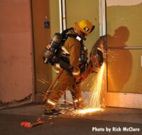 Firefighter cutting through a door