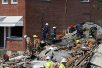 Authorities walk among the piles of debris