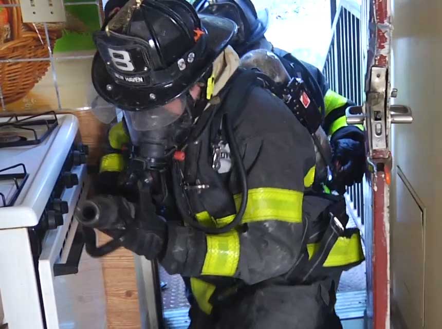 Firefighters using clamp for door control