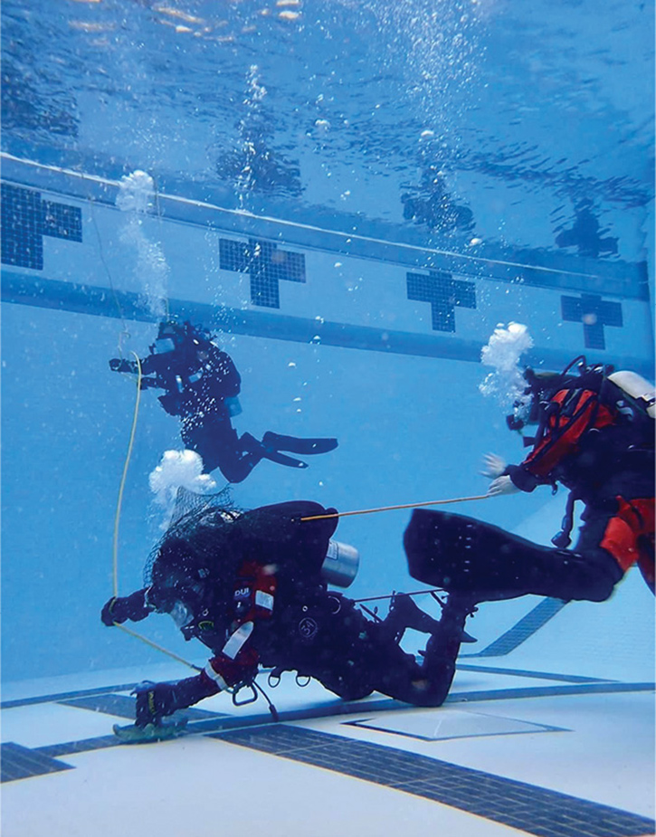 A diver is swimming in a set pattern and is presented with a single-problem entanglement by the instructor.