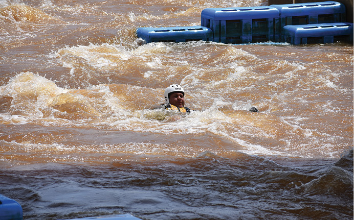 If a rescuer accidentally falls into the water, he must maintain proper body positioning and control until he can find a way out of the water. Notice that his head is up, he’s looking for hazards and escape routes as he moves downstream, and he’s keeping his feet up to avoid foot entrapment.