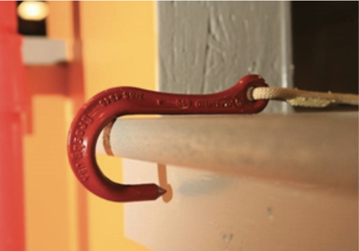 A hook is secured to the windowsill before the firefighter exits through the window.