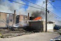 Firefighters aim hoseline on burning garage