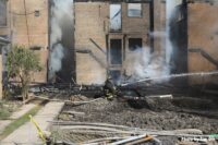 Firefighter with hoseline at burned out buildings