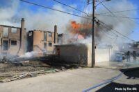 Firefighters with lines as flames burn top of garage