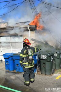 Firefighter with garage fire in background