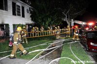 Firefighters with a ladder at Los Angeles house fire