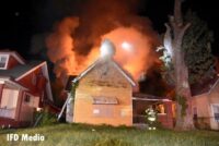 Flames and smoke rise from an intentionally set fire in Indianapolis as crews work