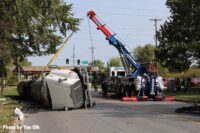 A crane truck lifts the rolled tanker truck