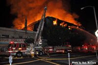 Flames shoot up to the sky as firefighters work