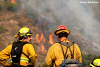 Firefighters in the foreground with Bobcat Fire behind them