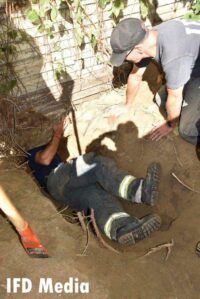 Indy firefighter underneath home trying to rescue dog