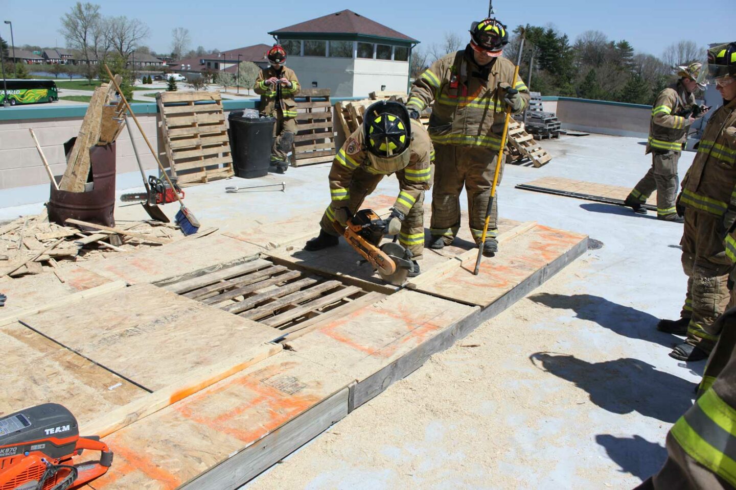 Firefighter guiding a cutting firefighter during a roof cut