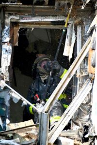 Firefighter performs overhaul at Queens fire