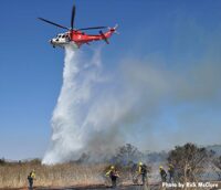 Helicopters makes drop on brush fire