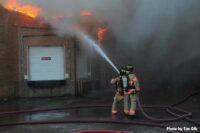 Firefighters use hoseline on exterior of the building