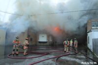 Firefighters pull lines toward burning building