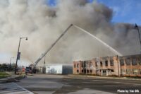 Aerial master stream with smoke from burning building