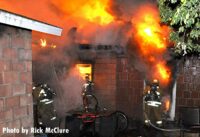 Raging flames shoot from a home as firefighters work to control a Tujunga fire