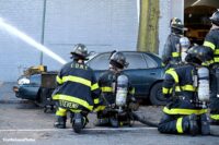 Firefighters train a hose stream into the building