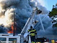 FDNY firefighter on tower ladder with master stream in use