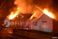 Firefighters put hoseline on the outside of a building