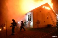 Firefighters at work at flames course through building